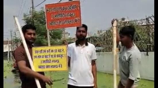 Residents standing on a makeshift raft with placards. (Sourced)