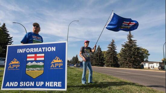 Separatists waves the Alberta flag by the roadside during an event advocating for Alberta's separation from Canada in Medicine Hat, southwestern Alberta, on September 23. (AFP)