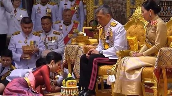 Former royal bodyguard Sineenat Wongvajirapakdi prostrates in front of King Rama X, while Queen Suthida watches in this image from 2019 (HT image)