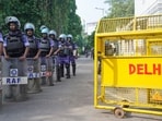 Rapid Action Force (RAF) personnel stand guard near Delhi Police barricades in New Delhi on Saturday. 