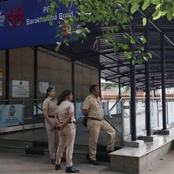 Police officers stand guard outside a closed metro station.