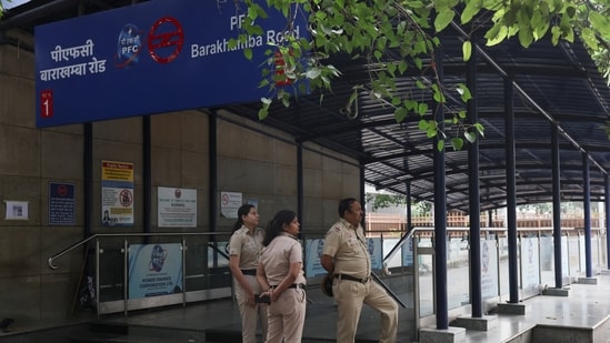 Police officers stand guard outside a closed metro station.