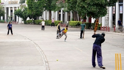 Youngsters play cricket on the deserted streets of the Inner Circle in Connaught Place on Sunday morning. (PTI)