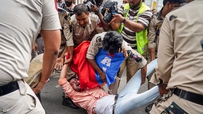 A protester being detained at Palika Bazar, Connaught Place, in New Delhi on Sunday. (ANI)