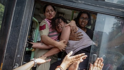 Policewomen try to prevent a detained protestor from escaping in New Delhi on Saturday. (Reuters)