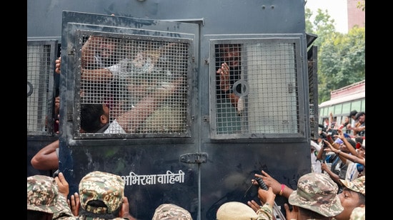 Police personnel detain protestors amid continued demonstration in Connaught Place area on Sunday. (PTI)