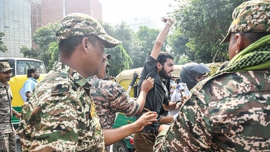 Paramilitary personnel detain protestors during a protest organised by Cockroach Janta Party, near Jantar Mantar in New Delhi on Saturday. (Bloomberg)