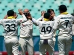 Nathan Lyon, center, celebrates with his teammates after dismissing South Africa captain Temba Bavuma.