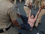 A protester is detained by police during a protest demanding the resignation of Gyanesh Kumar.