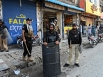 Police personnel stand guard along a street after the imposition of an emergency rule in Peshawar on October 12.