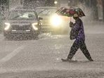 A person crosses a road amid rainfall, in New Delhi, Saturday, Aug. 9, 2025.
