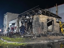 Rescuers work in a shop destroyed following a Russian missile attack in Pesochin settlement, a suburb of Kharkiv, which killed three people and wounded 22, on October 11, 2026, amid the Russian invasion of Ukraine. (Photo by SERGEY BOBOK / AFP)