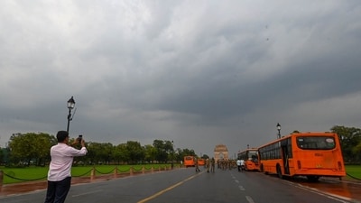 Gram it: A passerby attempts to get the perfect scenic shot as clouds hover over India Gate area after rain brought some cool to the city on Monday morning. (Photo: Arvind Yadav/ Hindustan Times))
