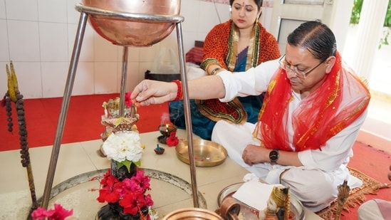 Uttarakhand Chief Minister Pushkar Singh Dhami and his wife, Geeta Dhami, perform a ritual while offering prayers in Dehradun on Sunday.