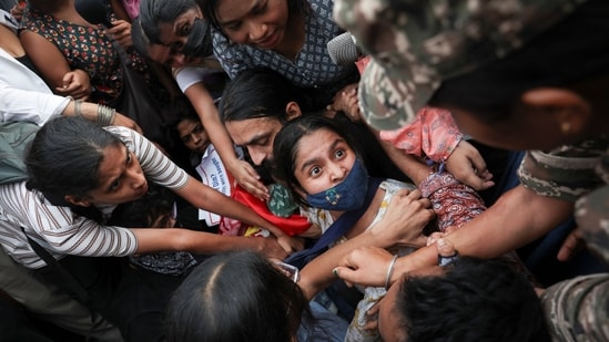 Delhi protests LIVE: Protesters react as they are detained by security personnel during a protest seeking the resignation of Chief Election Commissioner Gyanesh Kumar, in New Delhi.