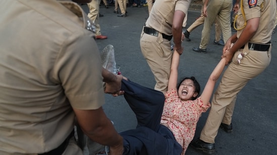 A protester is detained by police during a protest demanding the resignation of Gyanesh Kumar. (AP Photo)