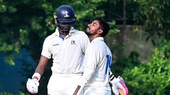 Bengal's Sudip Gharami celebrates his half century as Abishek Porel, left, looks on during the 2nd day of the Ranji Trophy cricket match between Bengal and Delhi