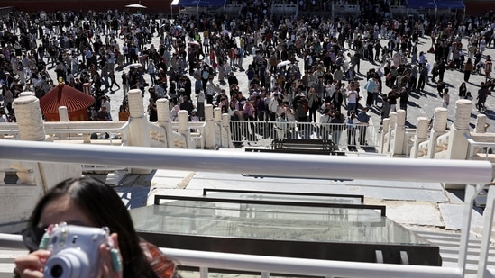 FILE PHOTO: A woman holds a camera as visitors tour the Temple of Heaven, also known as Tiantan Park, on National Day, the first day of China's Golden Week holiday, in Beijing, China, October 1, 2026. REUTERS/Florence Lo/File Photo (REUTERS FILE)
