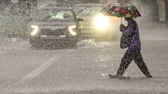 A person crosses a road amid rainfall, in New Delhi, Saturday, Aug. 9, 2025. (PTI)