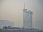 Gram it: A Metro train passes by a high-rise amid haze in Gurugram on Tuesday. In neighbouring Delhi, the AQI rose to 138 at 9.05am on TUesday, returning to the ‘moderate’ category after rain brought it down to 83, in the ‘satisfactory’ range, on Monday.(Photo: PTI)
