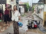 Residents stand amid waterlogged streets with a toppled two-wheeler after heavy rain triggered flooding in Bohri and Anand Nagar area, in Jammu on Sunday. (ANI Video Grab)