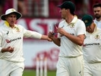 Australia's Pat Cummins, center, with his teammates leave the field as play is stopped due to bad light on day two of the first Test match between South Africa and Australia. 