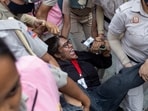 Security personnel detain a journalist during a protest by the Cockroach Janta Party on Sunday.