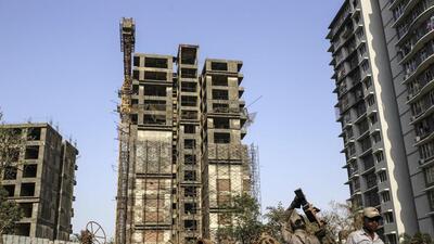 Workers collect scrap metal near an unfinished residential apartment project by Developer Orbit Corp., which collapsed in 2016, in the Andheri area in Mumbai, India, on Friday, Apr. 5, 2019. A series of economic shocks in the past three years have dented property-market sentiment and caused funding for developers to dry up. Many lack the funds to keep projects aimed at millions of more affluent citizens going. Photographer: Dhiraj Singh/Bloomberg (Bloomberg)