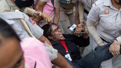 Security personnel detain a journalist during a protest by the Cockroach Janta Party on Sunday. (REUTERS)