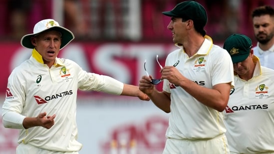 Australia's Pat Cummins, center, with his teammates leave the field as play is stopped due to bad light on day two of the first Test match between South Africa and Australia. 