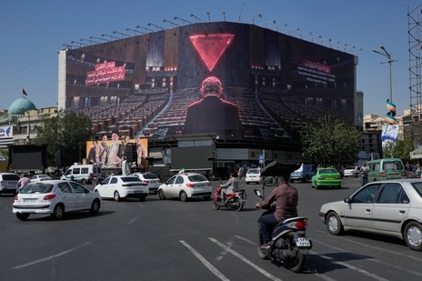 Vehicles drive past a huge billboard depicting Israeli Prime Minister Benjamin Netanyahu speaking at the U.N. General Assembly while seats are empty, referring to some delegations leaving the hall during his address in September, at the Islamic Revolution Square in Tehran, Iran, Monday, Oct. 12, 2026.
