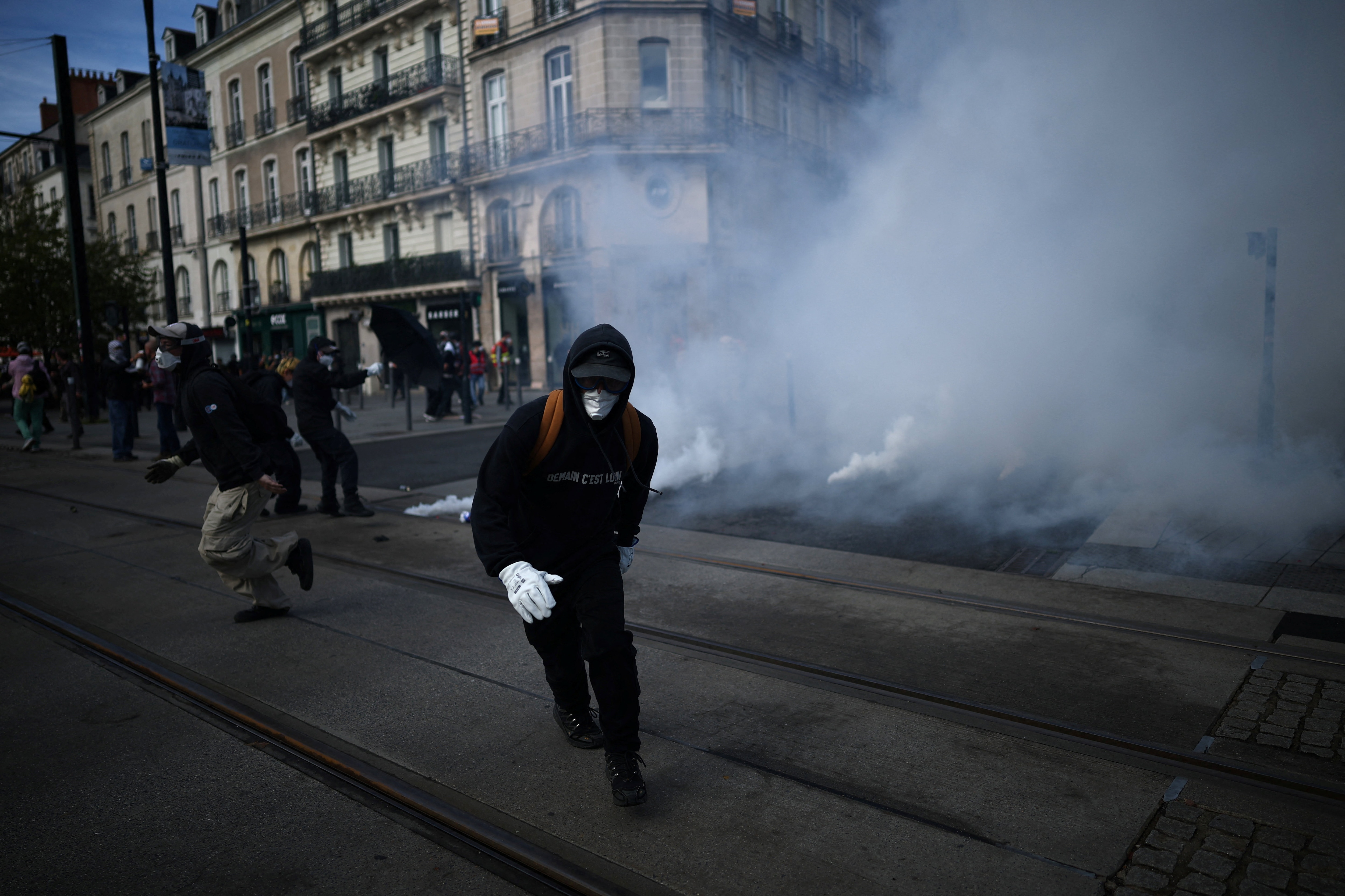 Masked protesters run amid tear gas during a demonstration in France as part of a nationwide protest movement led by students. (Reuters)