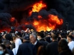 People gather near a fire as plumes of black smoke rise, amid an anti-government protest by students, in Tirana, Albania,