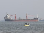 A boat floats as commercial vessels appear anchored in the Strait of Hormuz off Bandar Abbas, Iran, Oct. 13, 2026. (Razieh Poudat/ISNA via AP)