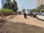 The road shoulders are unpaved, generating excessive dust every time a vehicle passes through. With vehicles constantly moving along the stretch, dust from the loose soil gets kicked up into the air and settles on nearby homes, cars and shops/ (HT Photo)