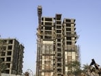 Workers collect scrap metal near an unfinished residential apartment project by Developer Orbit Corp., which collapsed in 2016, in the Andheri area in Mumbai, India, on Friday, Apr. 5, 2019. A series of economic shocks in the past three years have dented property-market sentiment and caused funding for developers to dry up. Many lack the funds to keep projects aimed at millions of more affluent citizens going. Photographer: Dhiraj Singh/Bloomberg (Bloomberg)