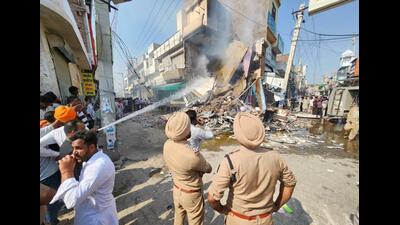 An agitated mob torched a chemist shop which was demolished by Mansa district authorities on Wednesday. The shop belonged to Ashwani Kumar, where he fatally shot Parvinder Singh Jhota on Tuesday morning. (HT Photo)