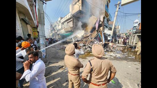 An agitated mob torched a chemist shop which was demolished by Mansa district authorities on Wednesday. The shop belonged to Ashwani Kumar, where he fatally shot Parvinder Singh Jhota on Tuesday morning. (HT Photo)