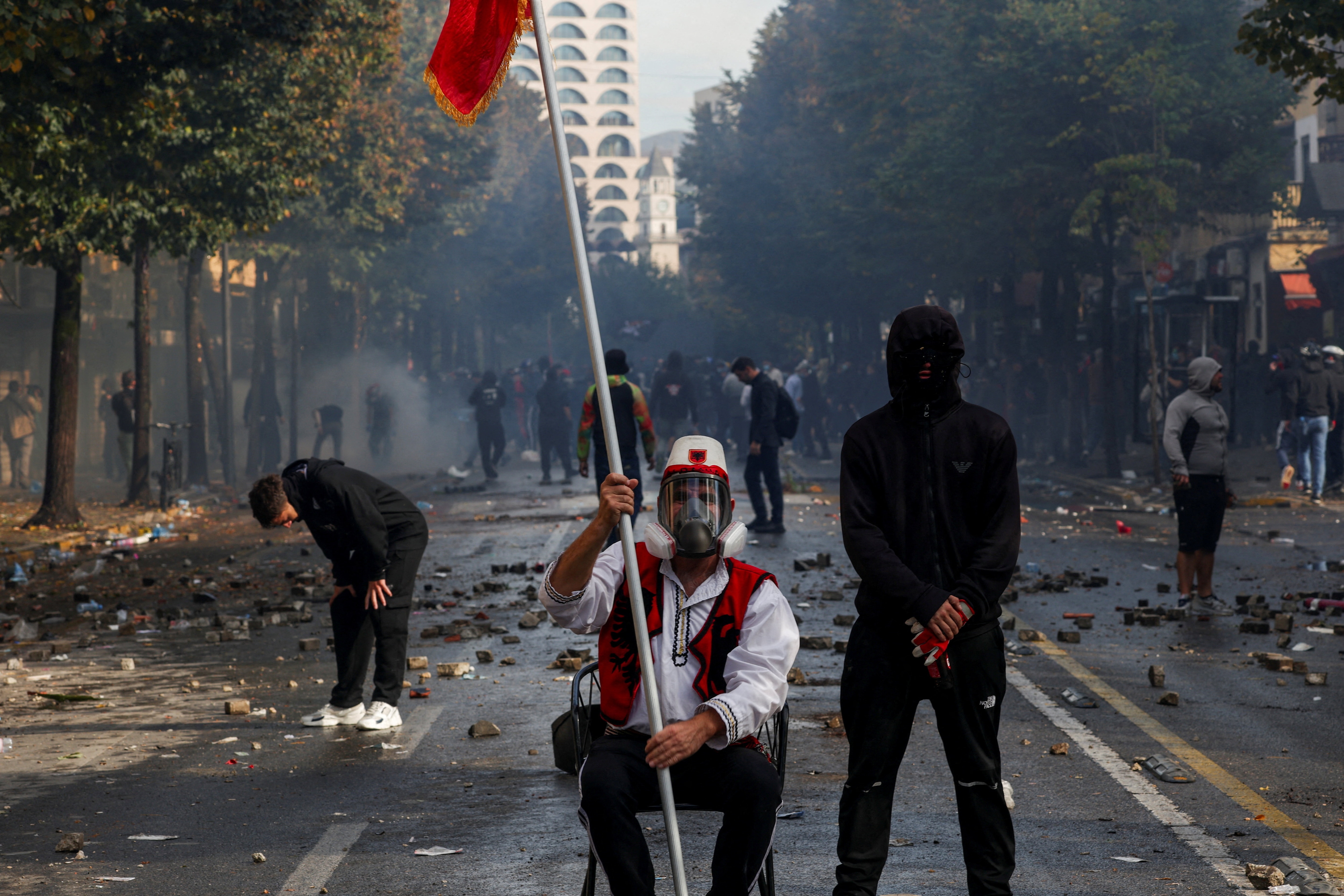 A man wearing an outfit resembling traditional Albanian attire sits amid scattered debris during an anti-government protest by students in Tirana, Albania, on October 14, 2026. (REUTERS)