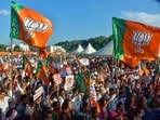 BJP supporters hold party flags
