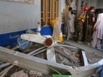 Rescue workers while searching through the rubble at the site of a roof collapse at a private school, in Peshawar,  Pakistan.