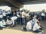 Protesting sugarcane farmers have a meal on the road during an ongoing indefinite highway blockade on the Pune-Bengaluru National Highway (NH-48), in Belagavi district, Karnataka, Wednesday. Traffic on NH-48 towards Belagavi and Bengaluru has returned to normalcy after the protest at the Kognoli toll plaza in Karnataka was called off; the Maharashtra highway police said on Wednesday. (PTI)