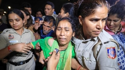 Police personnel detain parents of 19-year-old Ankita Bhandari, who was murdered in Uttarakhand in 2022, while protesting near India Gate against Dushyant Kumar Gautam's appointment as Sikkim governor, in New Delhi.