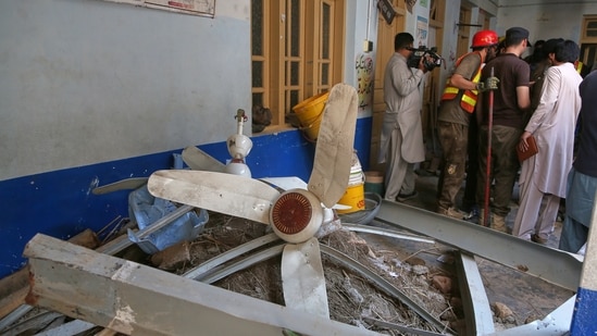 Rescue workers while searching through the rubble at the site of a roof collapse at a private school, in Peshawar,  Pakistan.