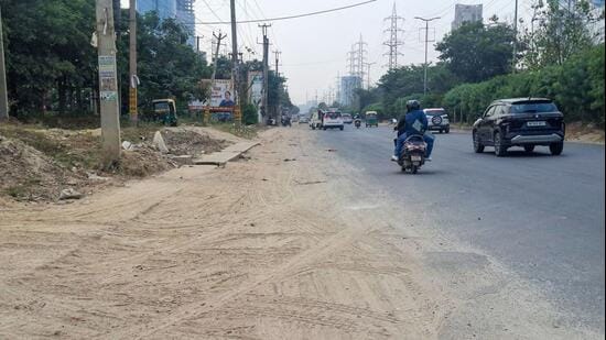 The violations included visible accumulation of road dust and C&D waste, damaged footpaths and potholes, which CAQM said contributed to dust generation and its resuspension by moving vehicles, worsening ambient air quality. (HT Photo)