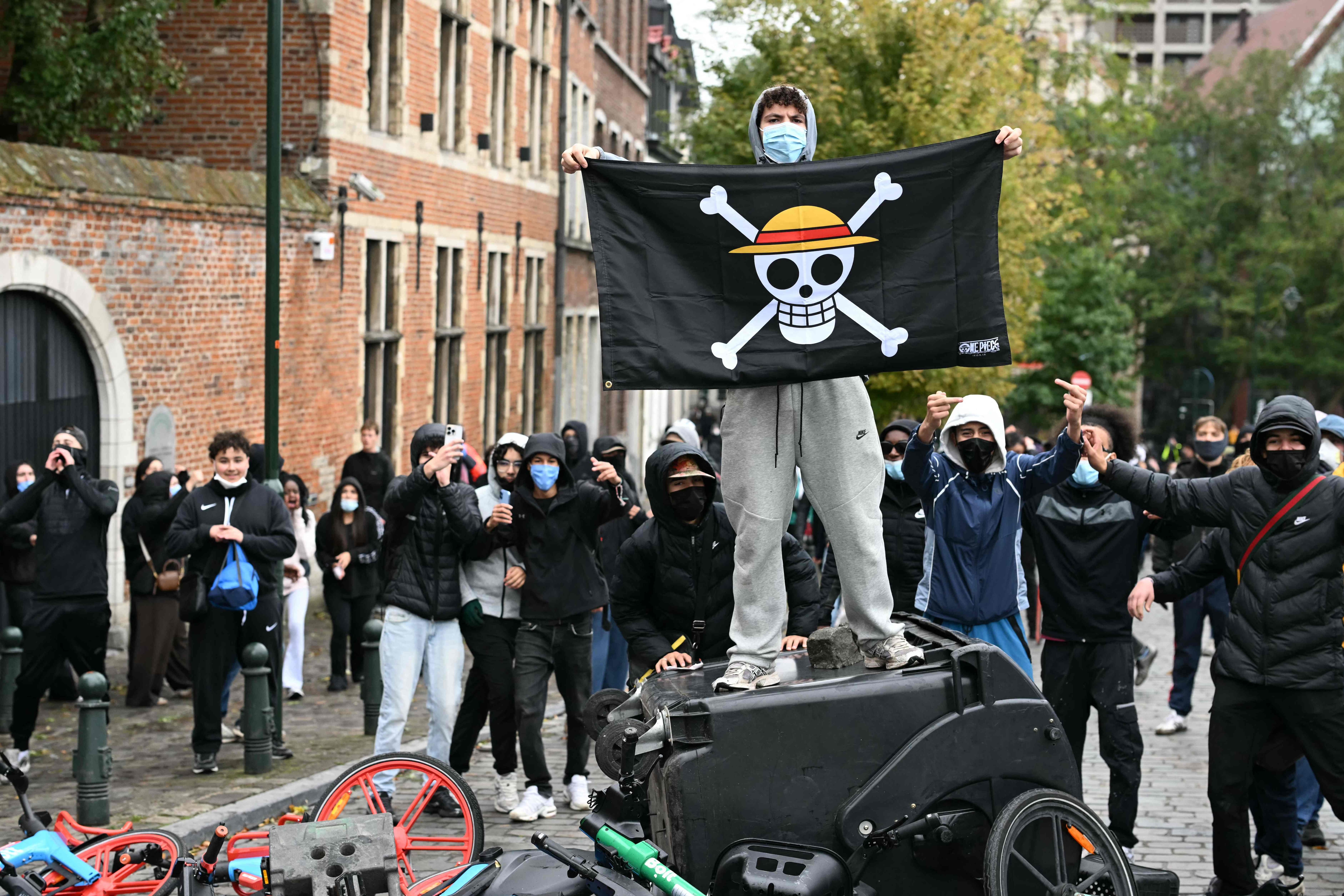 A protester brandishes a flag referencing Straw Hats' Jolly Roger pirate flag of Japanese manga and anime One Piece during a labour union-based demonstration against the Federal Government's budgetary measures in Brussels. (AFP)