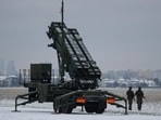 Servicemen patrol in front of the Patriot air defence system during military training, at the airport in Warsaw, Poland.
