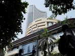 File: Men walk past a screen displaying market results outside the Bombay Stock Exchange (BSE) in Mumbai