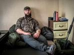 Stupnikov at his temporary apartment in Ukraine, where two sacks contain all his possessions and an anti-drone gun rests against the wall