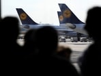 FILE PHOTO: Passengers are silhouetted near airplanes of German airline Lufthansa that are parked at Frankfurt airport July 31, 2008. REUTERS/Kai Pfaffenbach (GERMANY)/File Photo